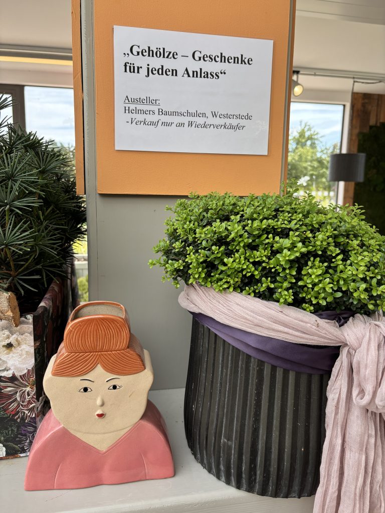 Das Motto der Ausstellung, davor ein Pflanztopf in Frauenoptik