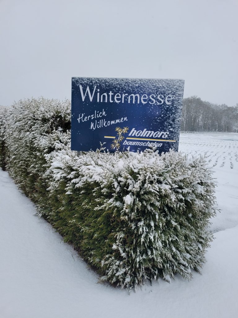 Das Schild der Helmers Wintermesse ist verschneit